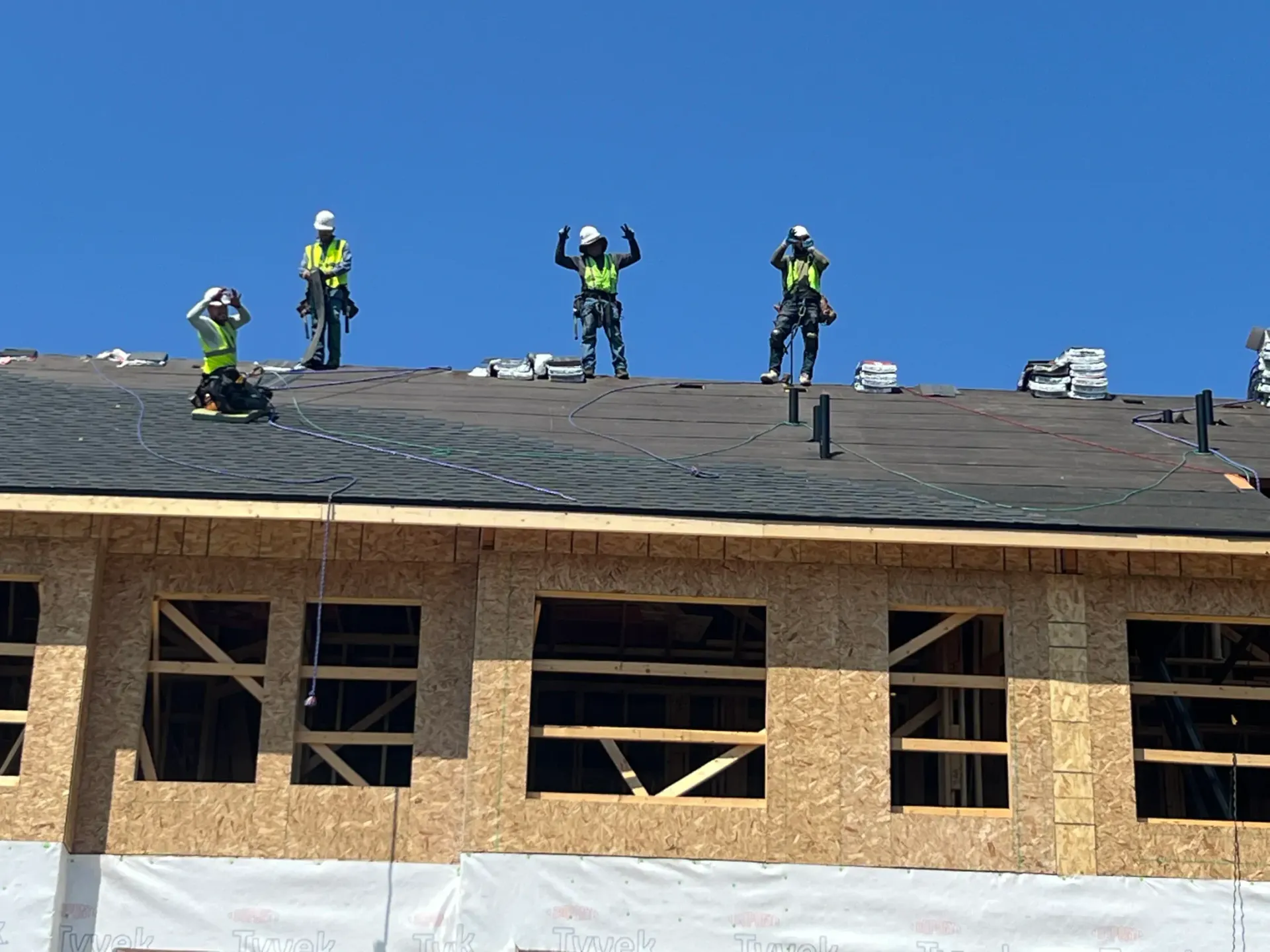 A group of construction workers are working on the roof of a building under construction.