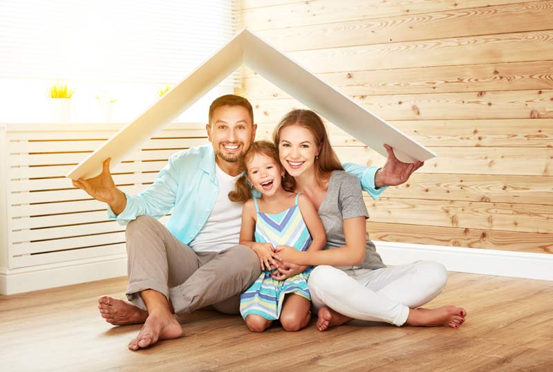 Couple smiling with their daughter in their new home