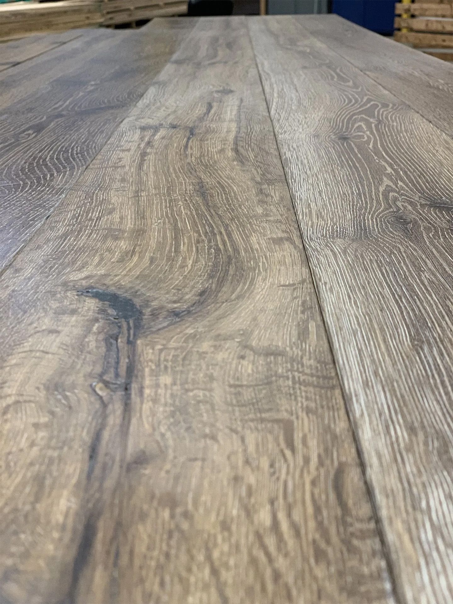 Close-up of rustic gray-brown wooden planks with visible grain and knots.