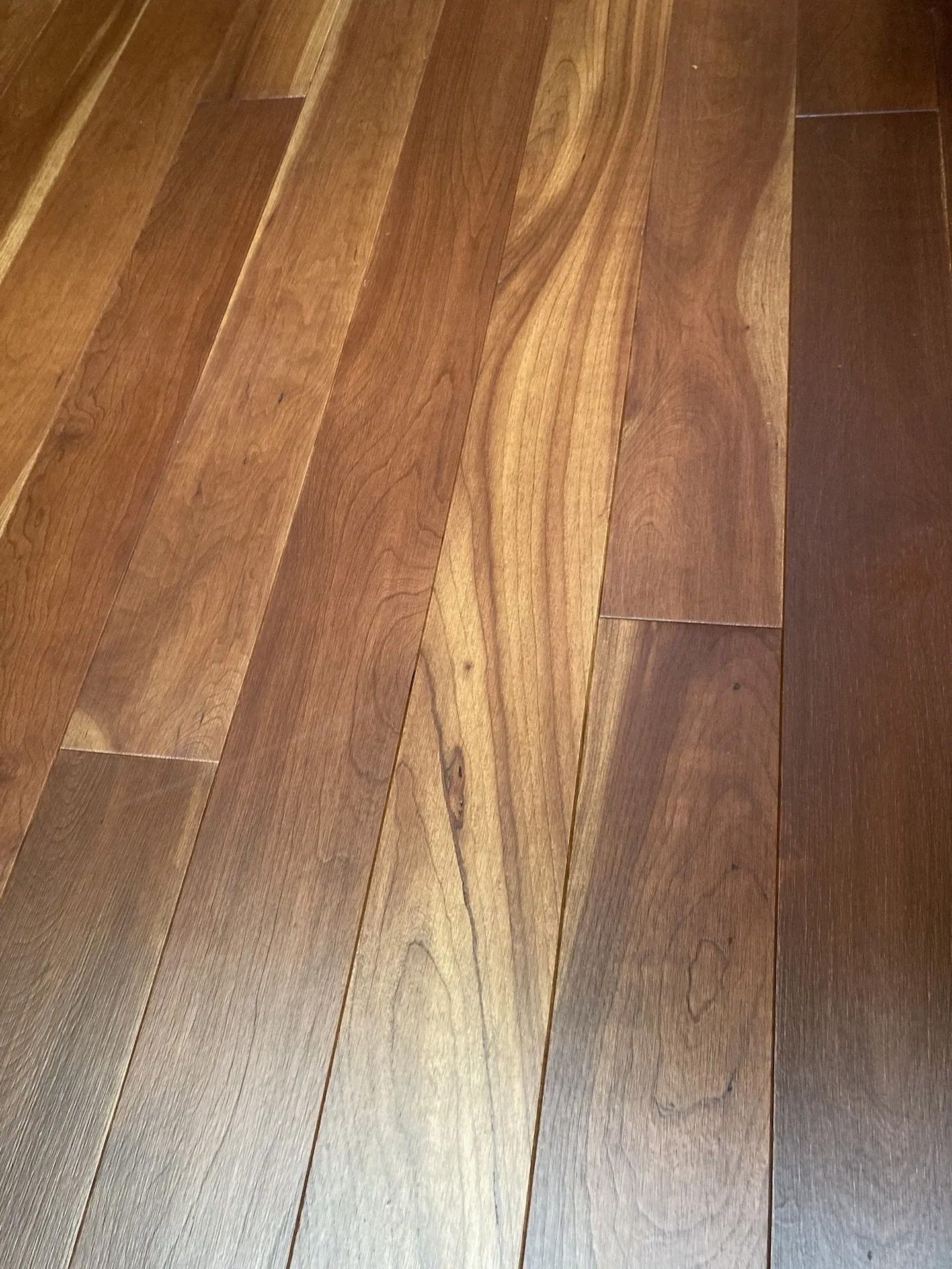 Close-up of warm-toned wooden floor planks with varied grain and color patterns.