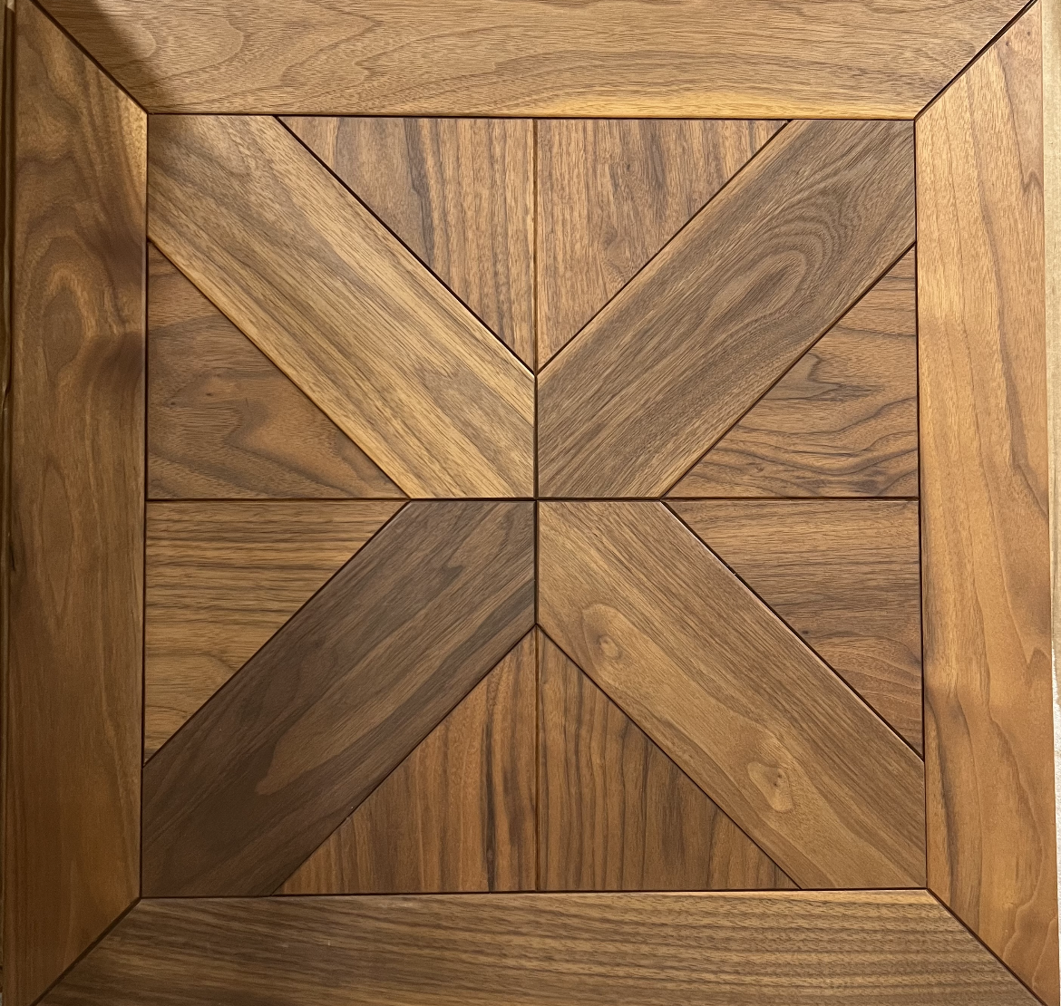 Wooden square mosaic with a geometric star pattern in warm brown tones