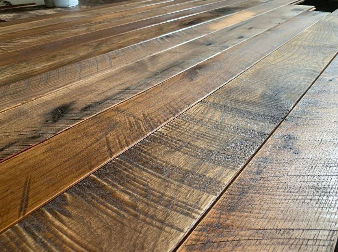 Close-up of rustic wooden floor planks with warm brown tones and visible grain.