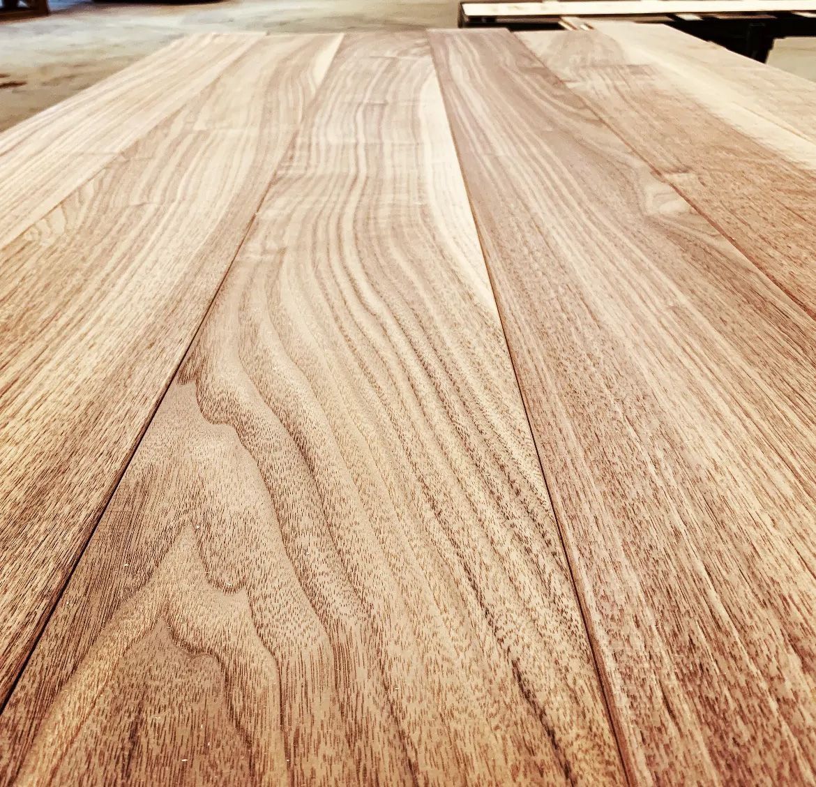 Light-colored wood tabletop with visible grain and planks, viewed from a low angle