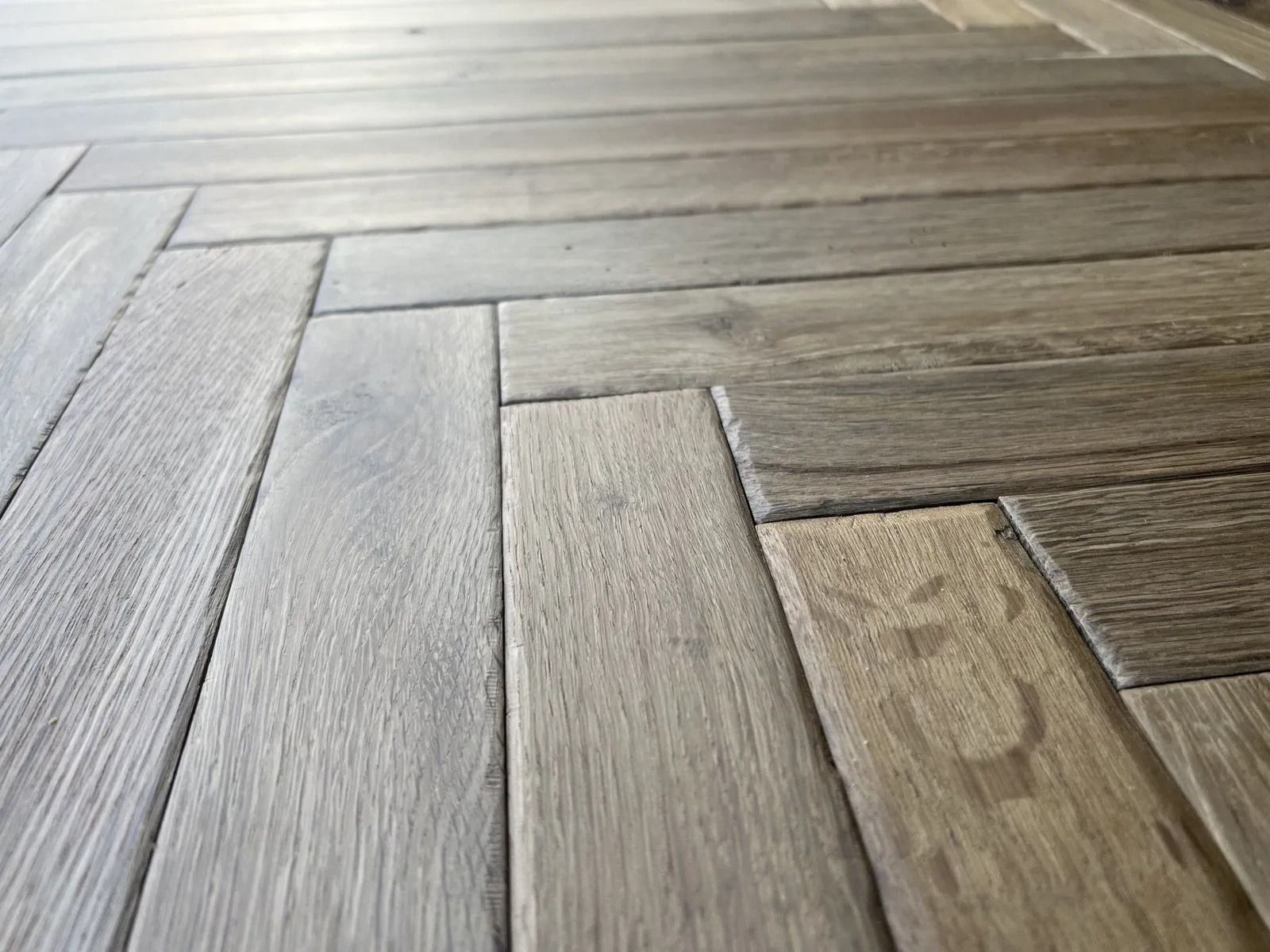 Gray and brown herringbone wood floor planks close-up