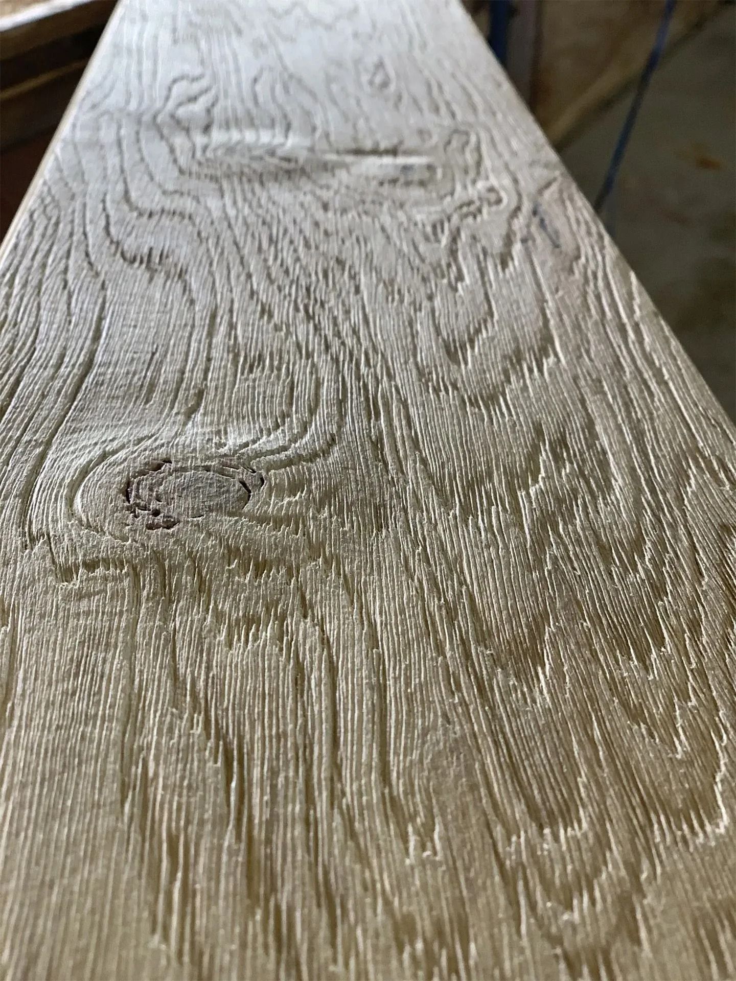 Close-up of weathered light wood grain with knots and textured surface