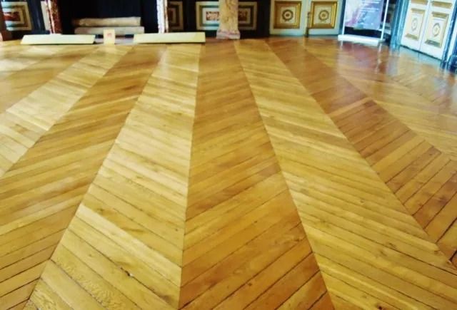 Polished herringbone wooden floor with chevron inlay in a gallery-like room
