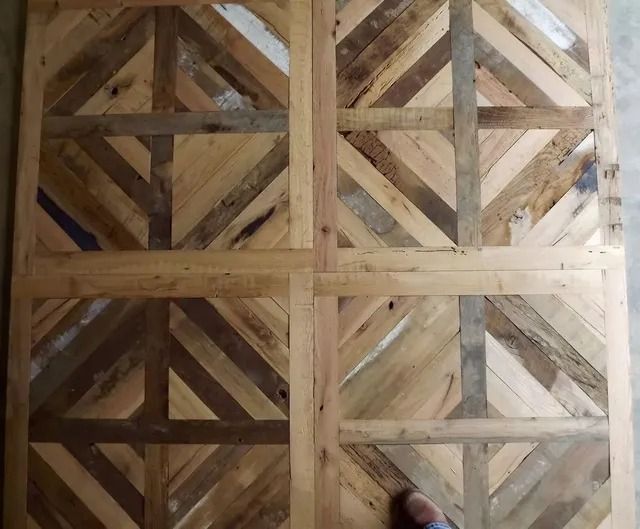 Wooden lattice floor or wall panel with diagonal braces, viewed from above.