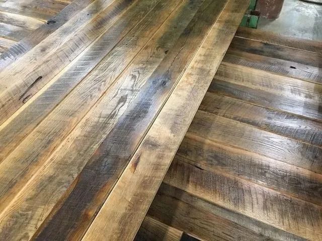 Wooden plank flooring with varied gray, brown, and tan tones and a worn rustic finish
