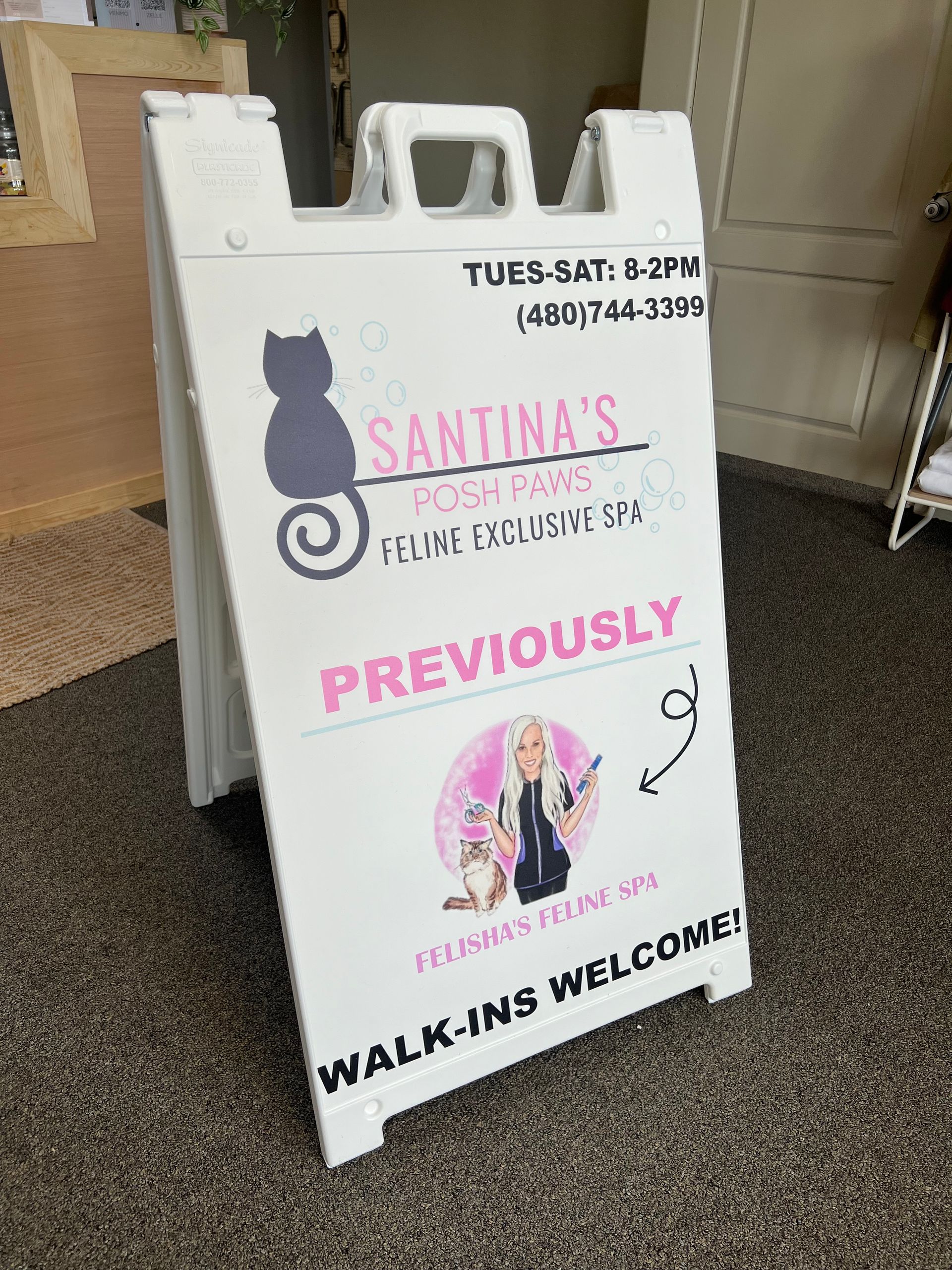 White A-frame sign outside business. Sign reads