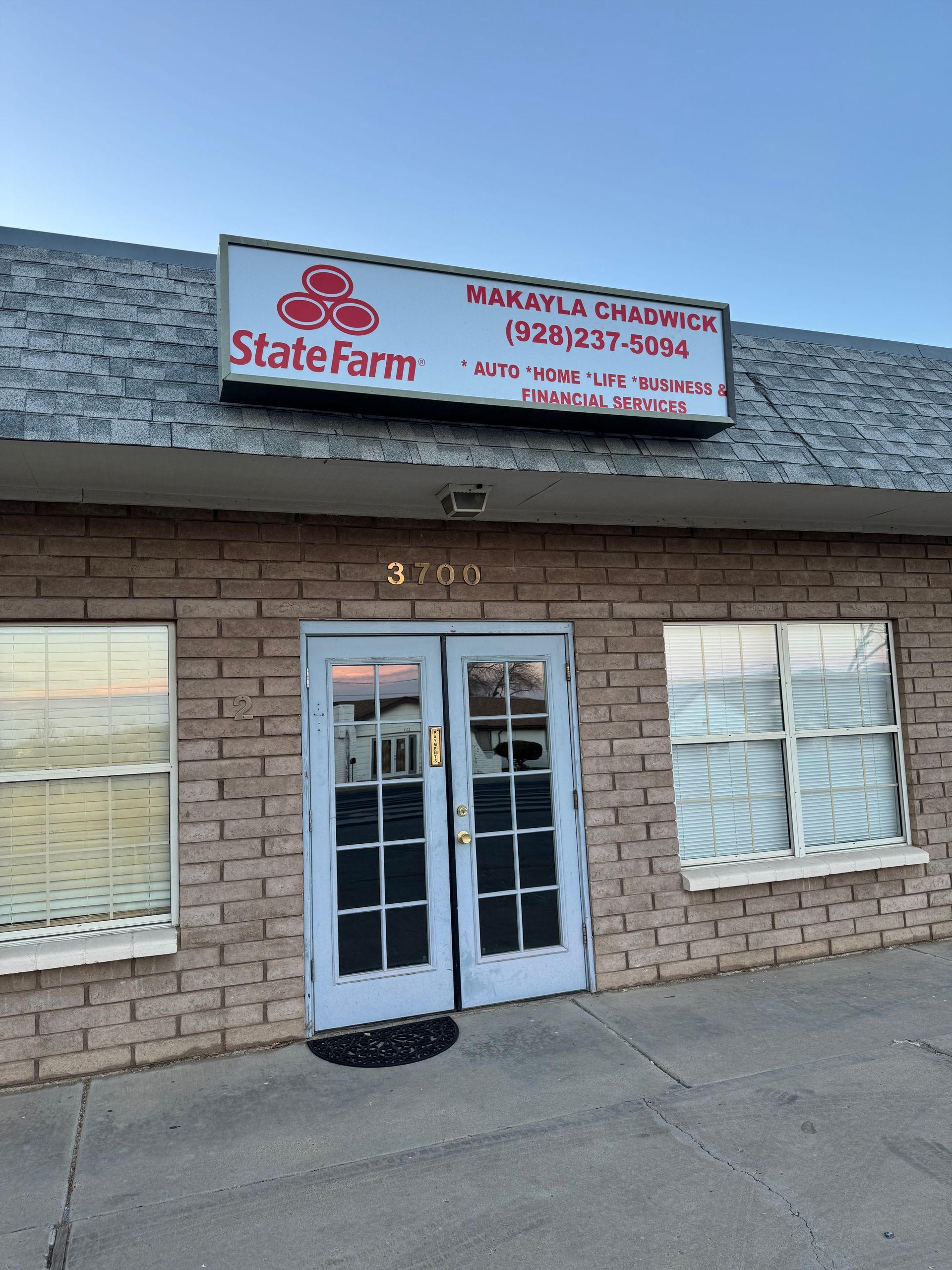 State Farm office with a sign above the entrance. Includes contact information. The building is brick.