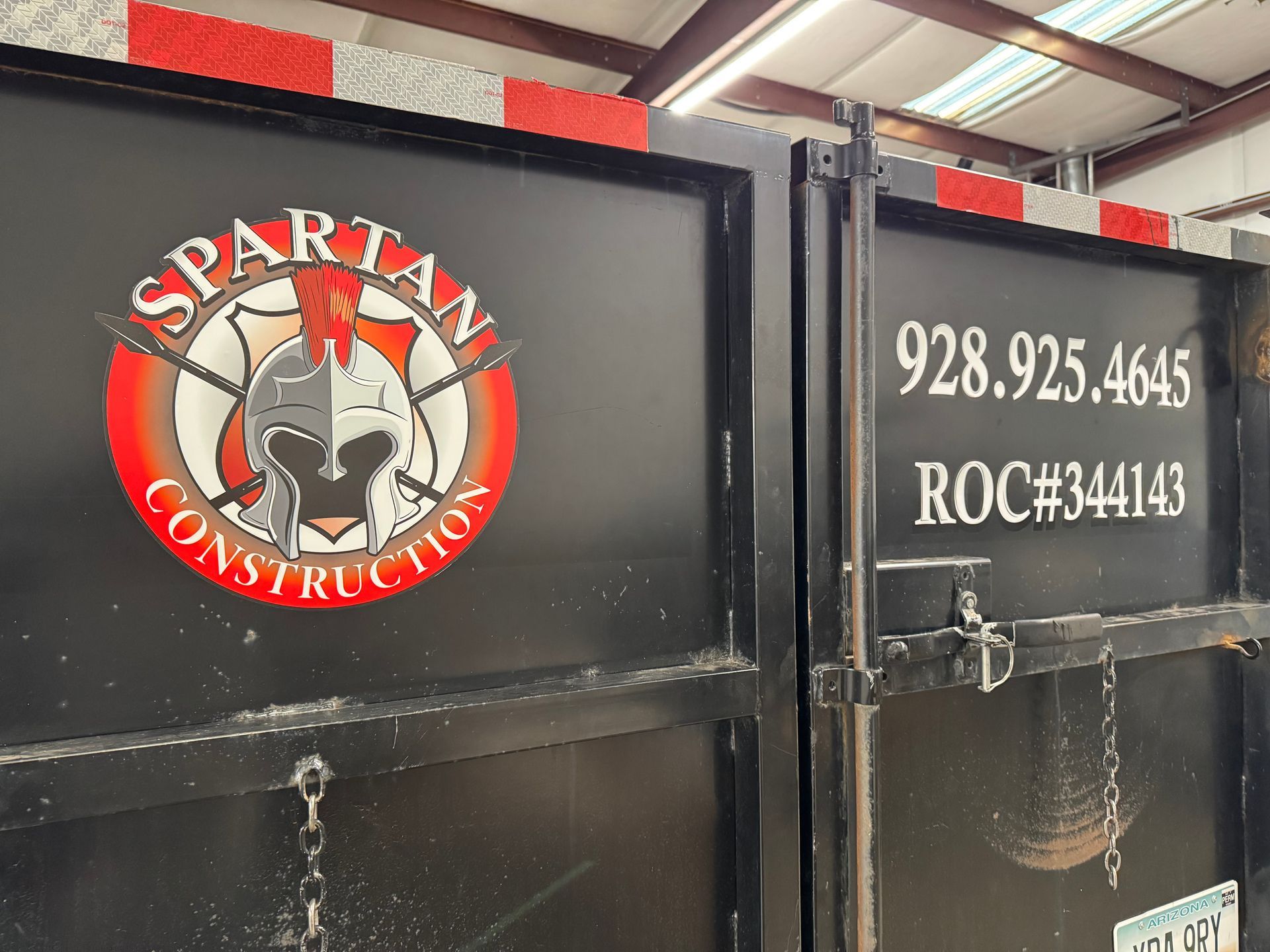 Spartan Construction logo on a black container, with a phone number and contractor license number displayed.