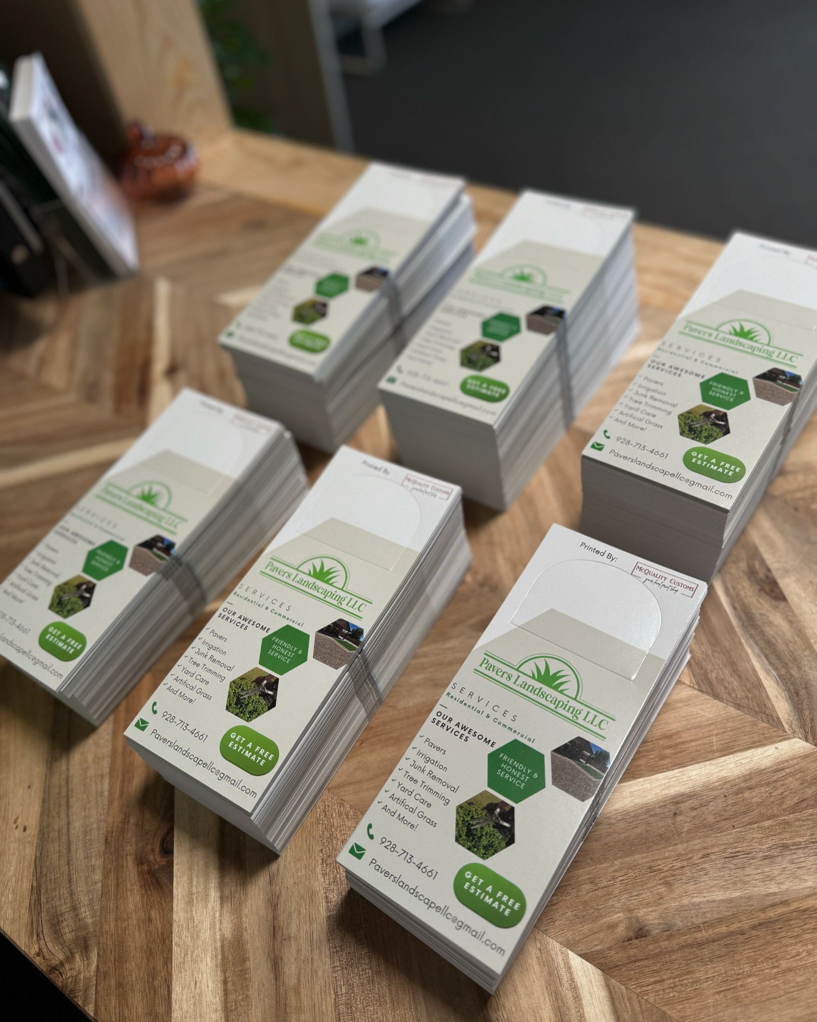 Stacks of brochures on a wood surface. Brochures have a green and white color scheme.