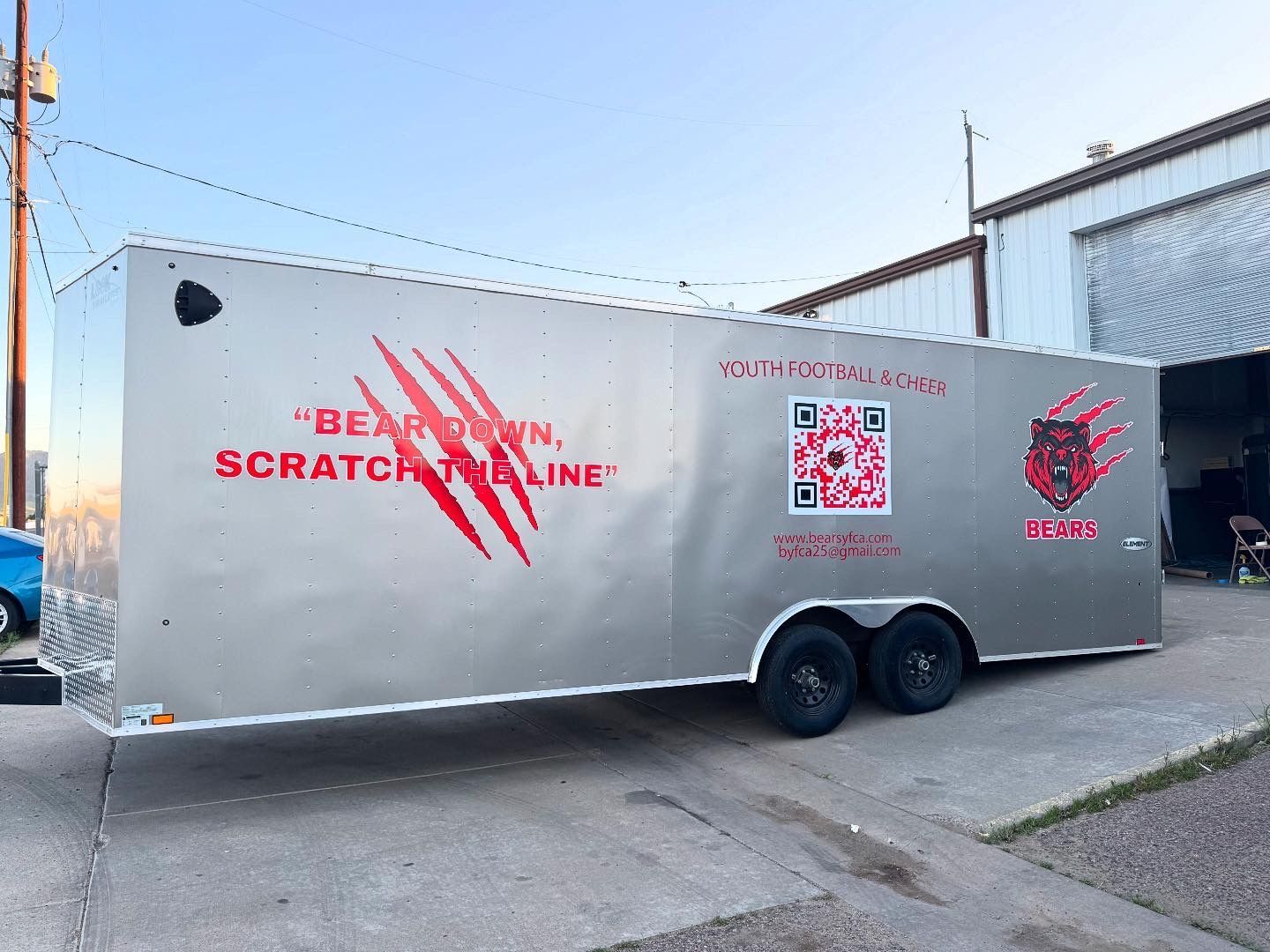 Silver trailer with red claw marks, text, and a QR code. 