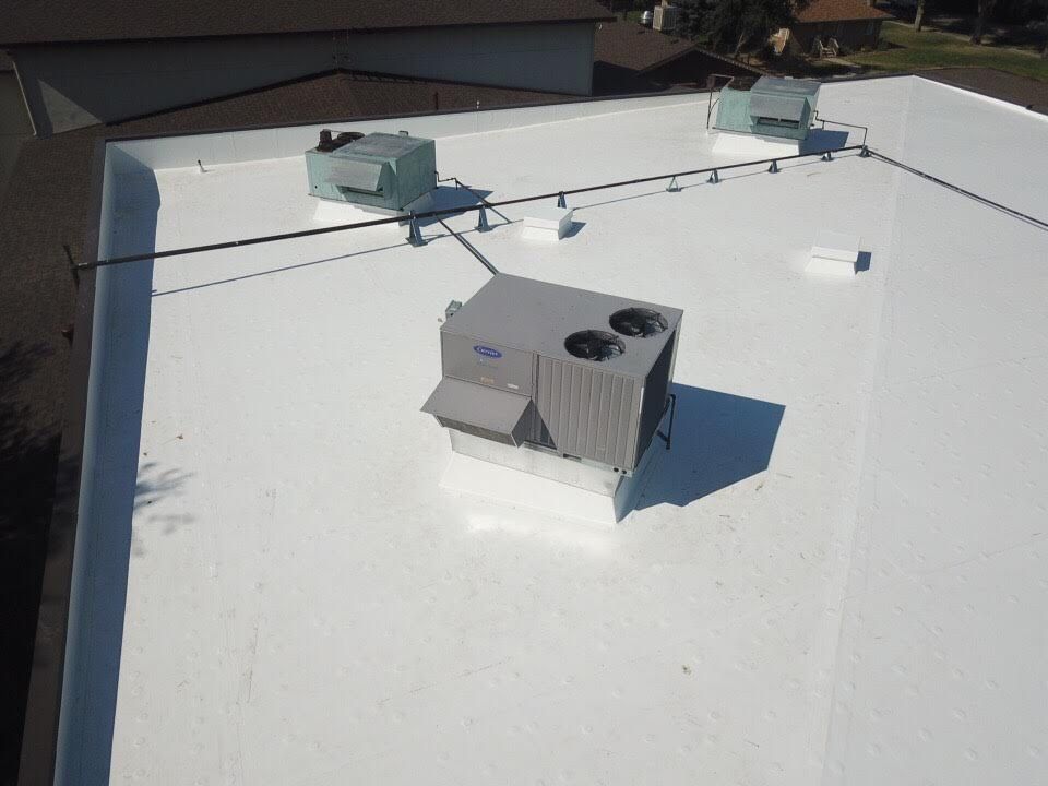 White commercial flat roof with HVAC units and dark safety lines.