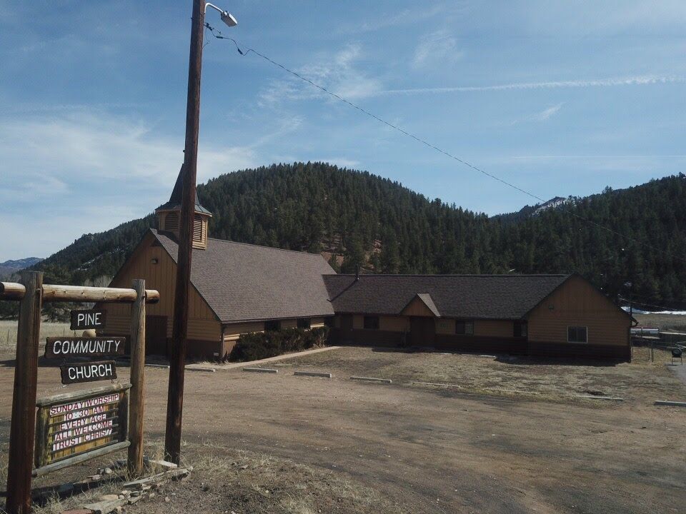 Pine Community Church with a mountain backdrop.