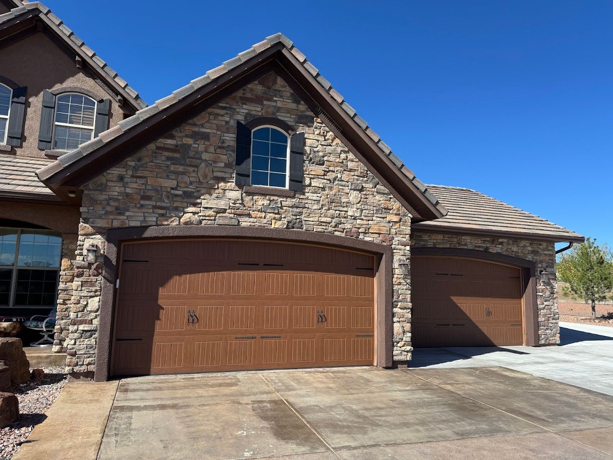 Spacious foyer with a curved staircase, wood floors, and a rug; an open view of a living room.
