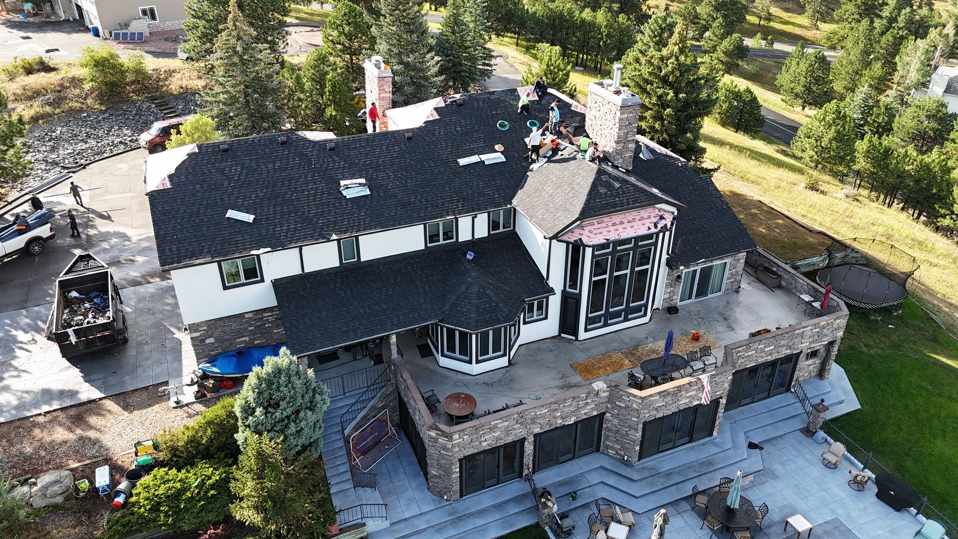 Aerial view of a two-story house with a partially completed roof replacement.