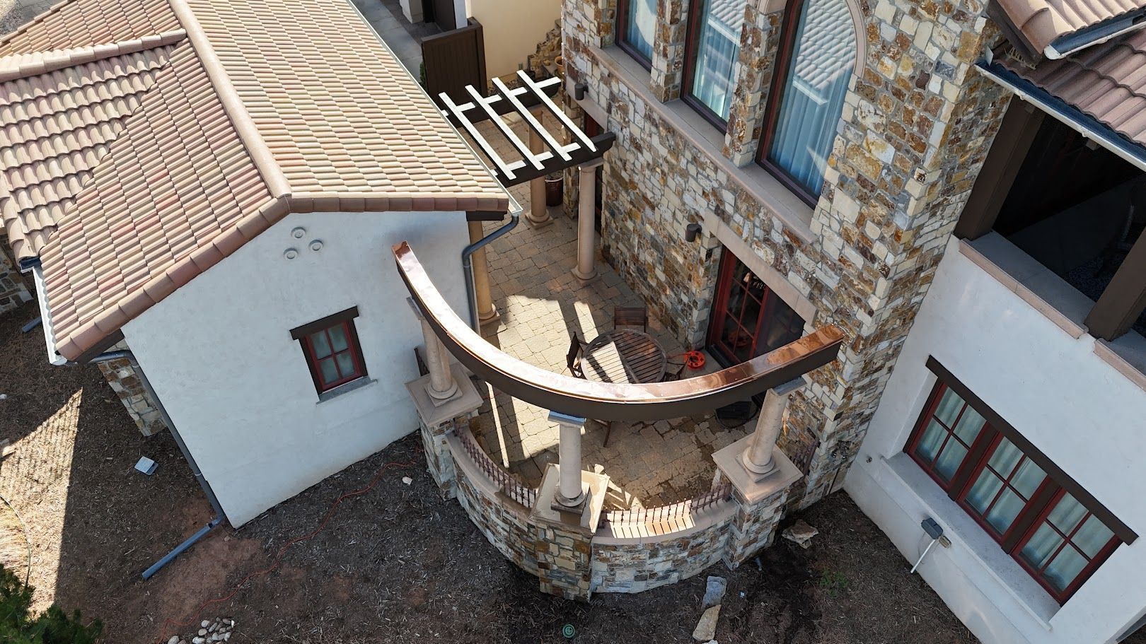 Two-story house with a ladder on the roof under an overcast sky.
