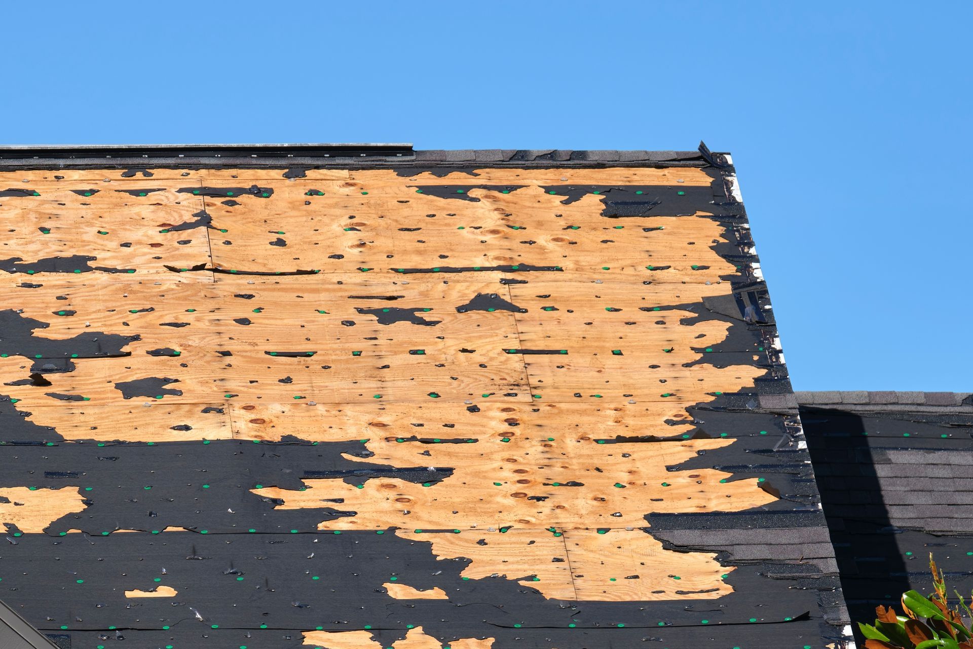 Weathered orange and black building wall with peeling paint under a blue sky