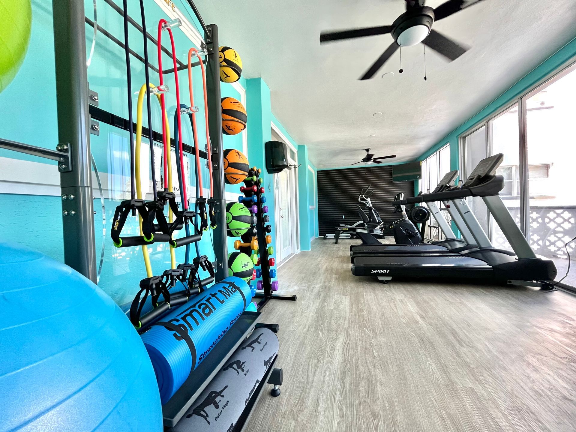 Gym with equipment, including treadmills, resistance bands, yoga mats, and exercise balls.