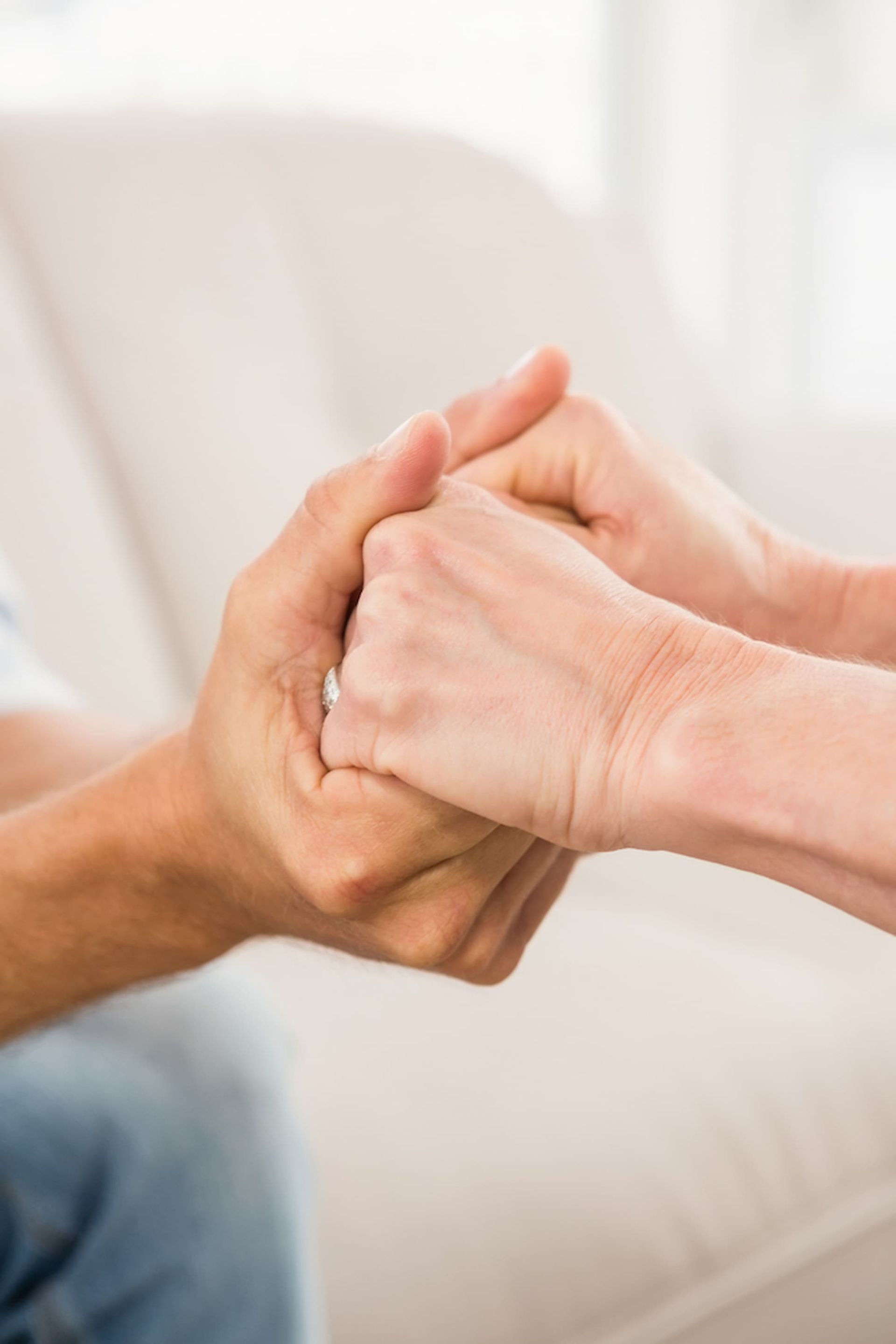 A Man and A Woman Are Holding Hands While Sitting on A Couch — Psych Solutions NT in Katherine, NT