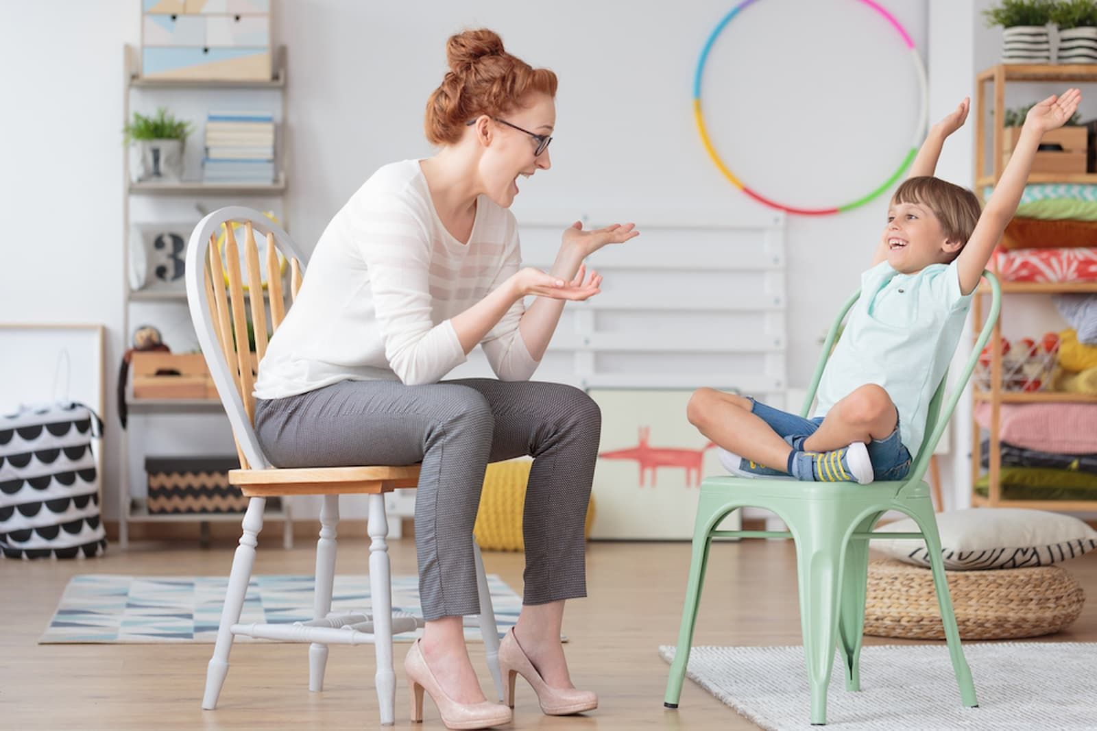 A Woman Is Sitting in A Chair Talking to A Young Boy Who Is Sitting in A Chair — Psych Solutions NT in Leanyer, NT