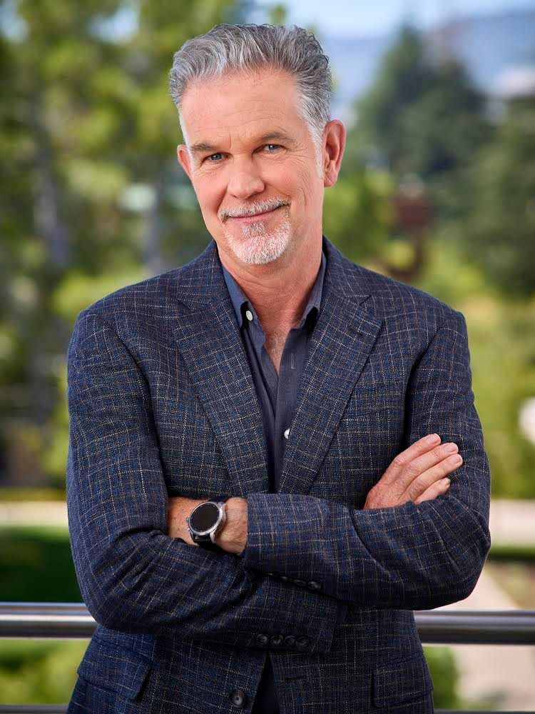 An image of a smiling Reed Hastings taken from the front with his arms crossed