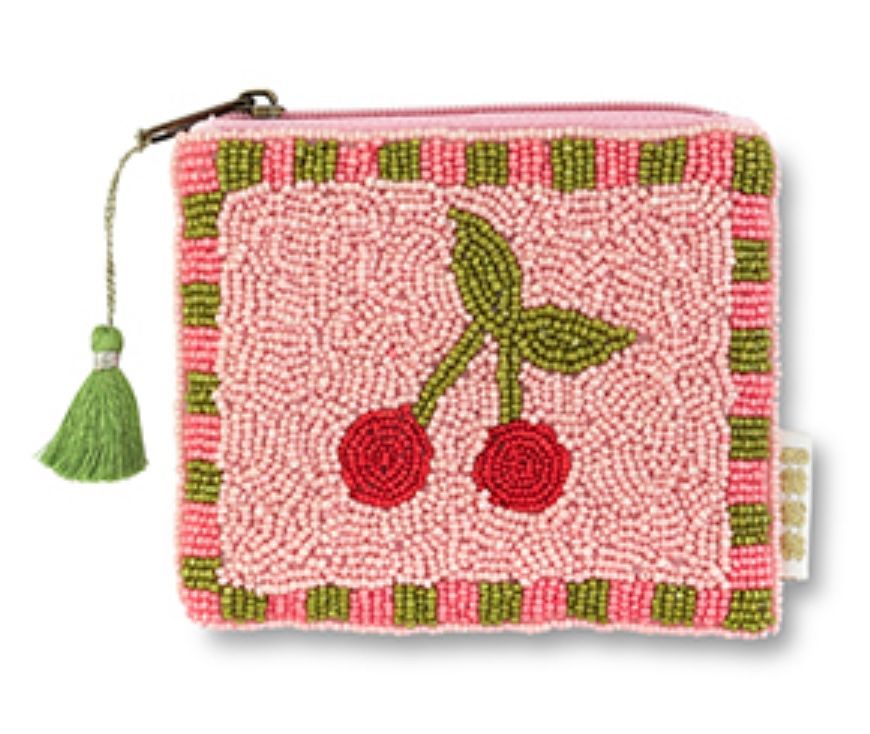 Een klein, roze, vierkant portemonneetje met kraaltjes, versierd met twee rode kersen met groene blaadjes en een groene kwast als ritssluiting.