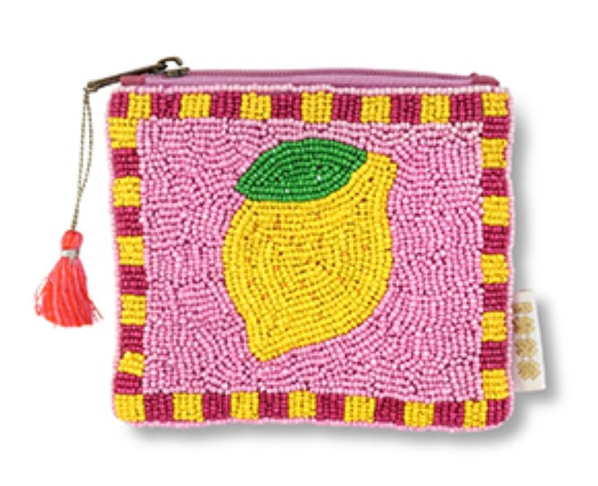 Een vierkant portemonneetje met kralen, versierd met een gele citroen en een groen blad op een roze achtergrond, met een roze kwastje als ritssluiting.