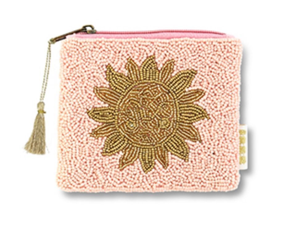 Een lichtroze portemonneetje met kralen, een goudkleurig zonnebloemmotief van kralen in het midden en een bijpassende kwast aan de ritssluiting.