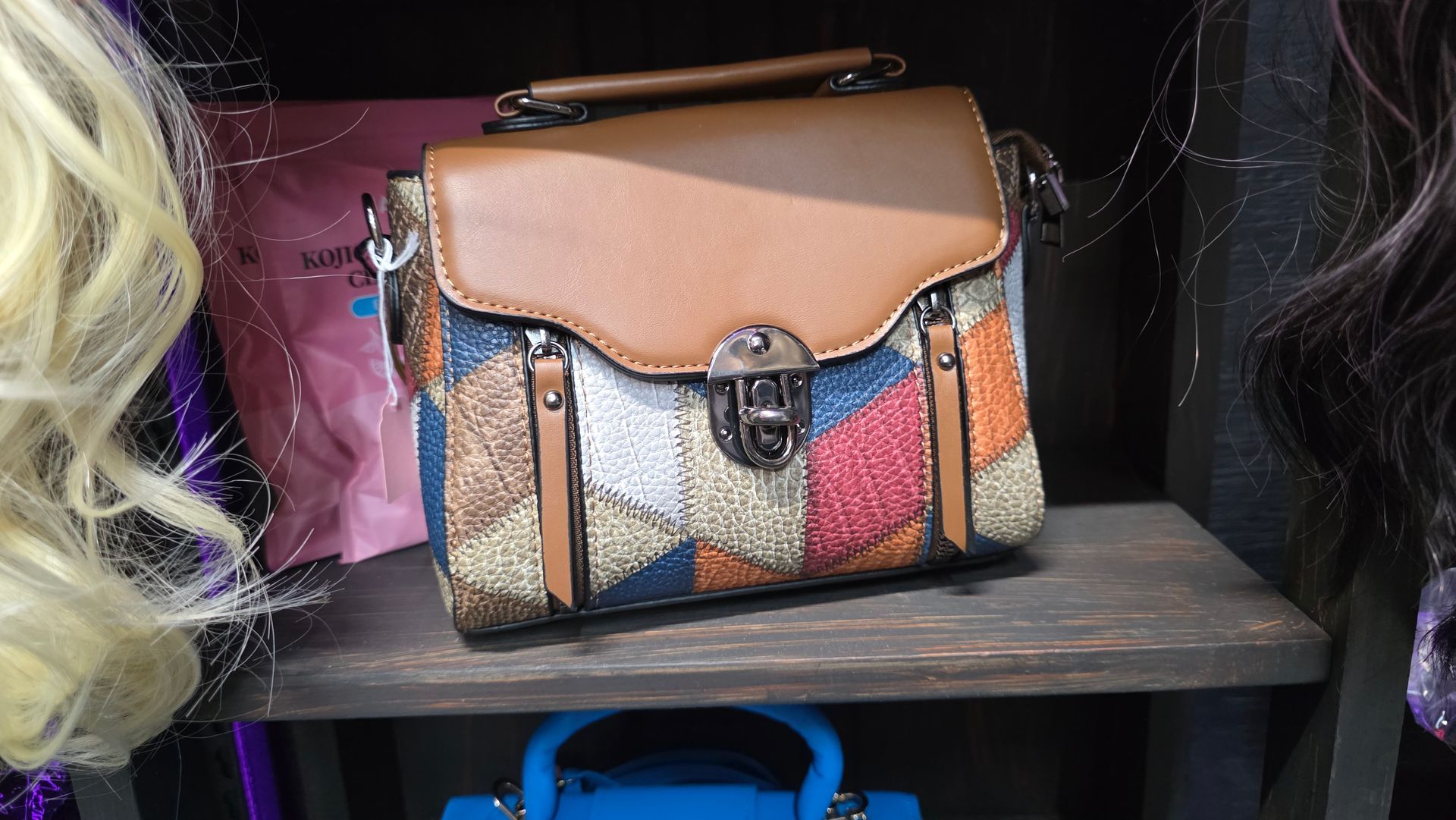 Brown and patchwork shoulder bag on a shelf.