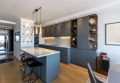 Modern kitchen with blue cabinets, marble island, pendant lights, and hardwood floors Modern kitchen with blue cabinets, marble island, pendant lights, and hardwood floors