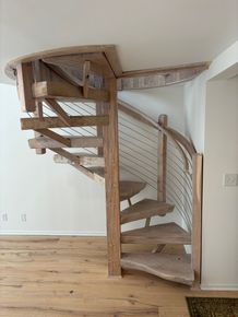 Curved wooden spiral staircase in a bright room with white walls and light wood floor Curved wooden spiral staircase in a bright room with white walls and light wood floor