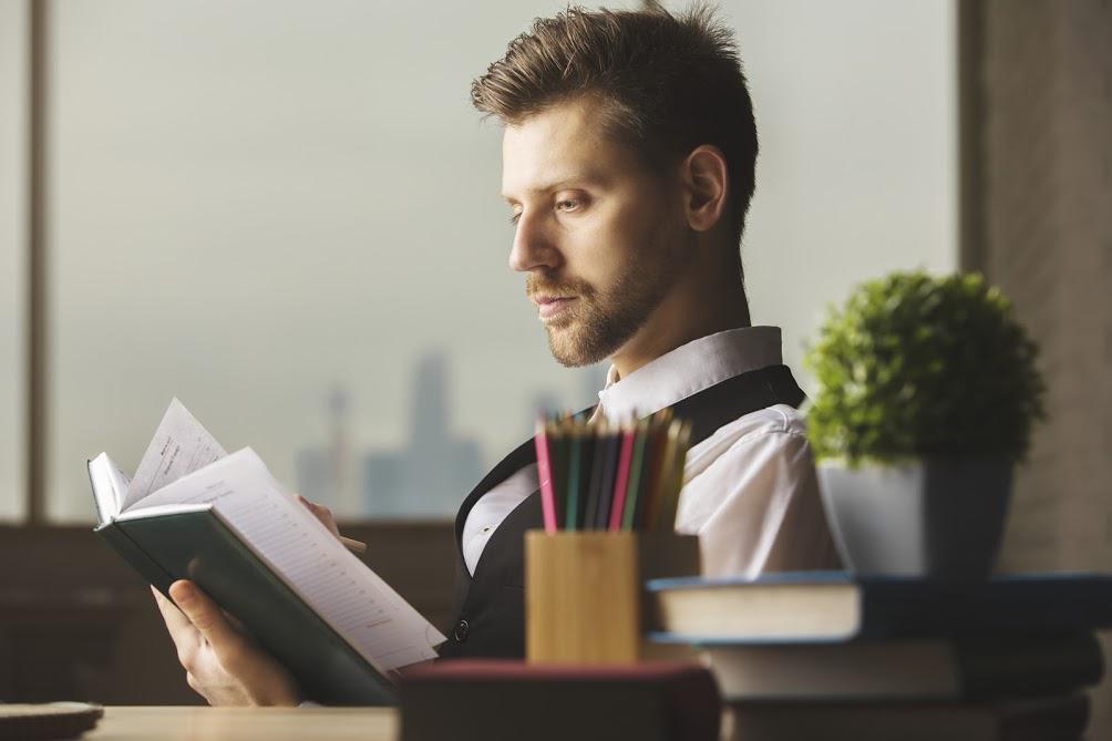 Handsome Young Businessman Reading Book — Eatontown, NJ — Executive Suites at 12 Christopher Way