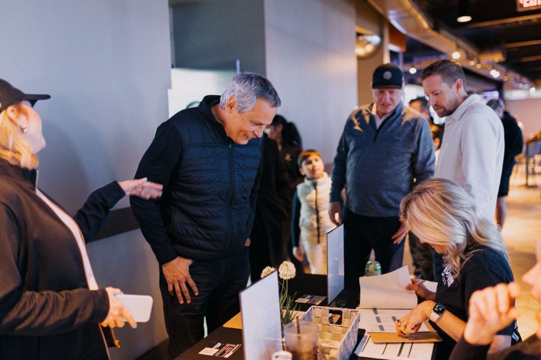 A group of people are standing around a table in a room.