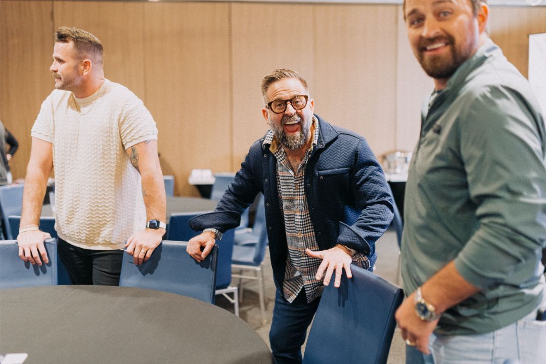 A group of men are standing around a table in a room.