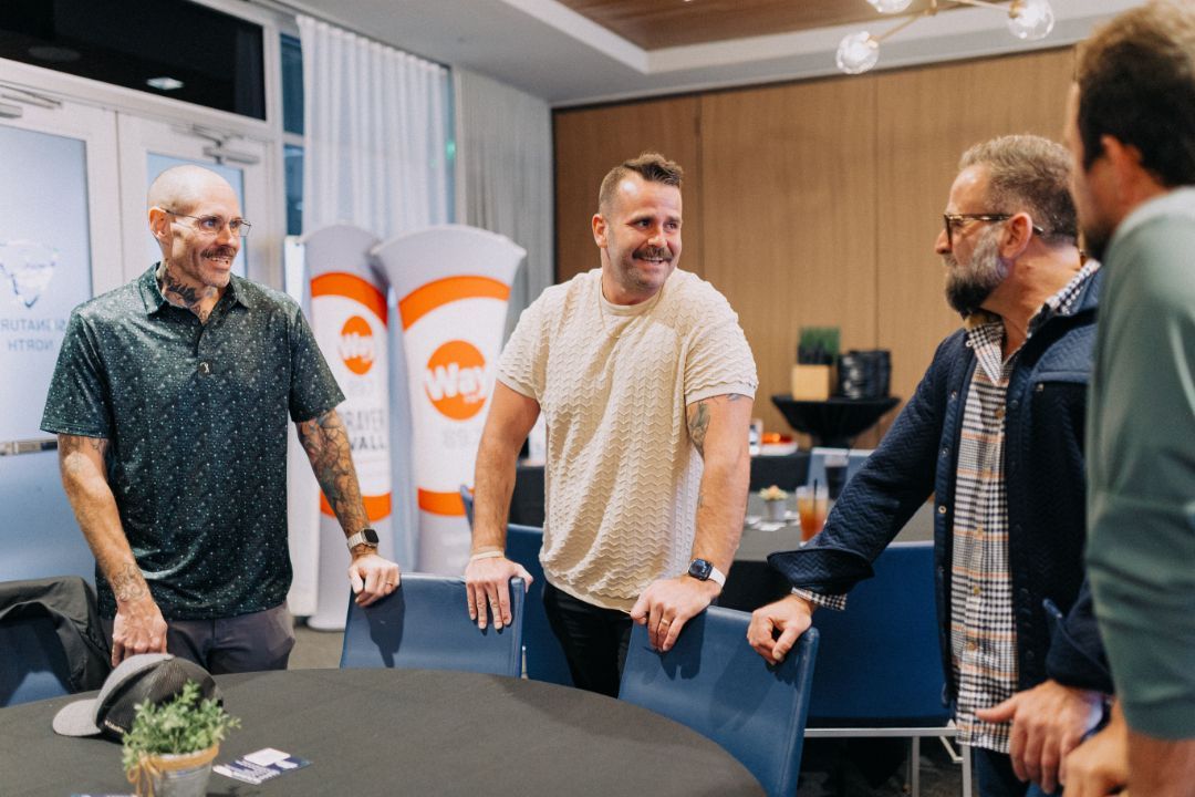 A group of men are standing around a table in a room.