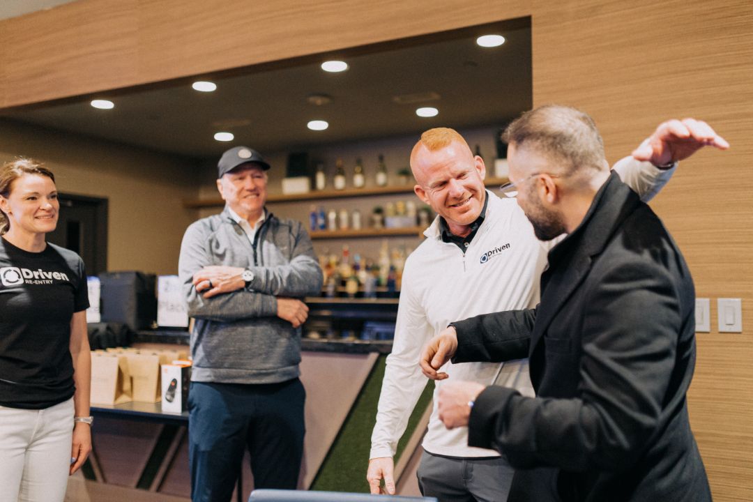 A group of people are standing around a table in a room.