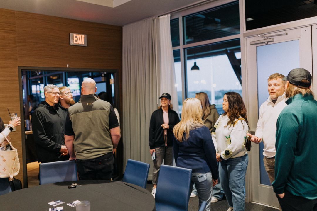 A group of people are standing around a table in a room.