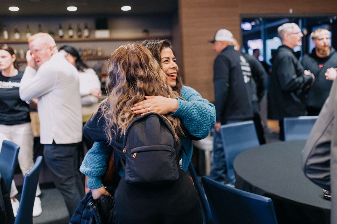 A group of people are hugging each other in a room.