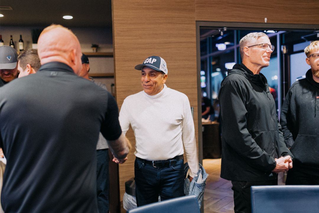 A group of men are shaking hands in a room.