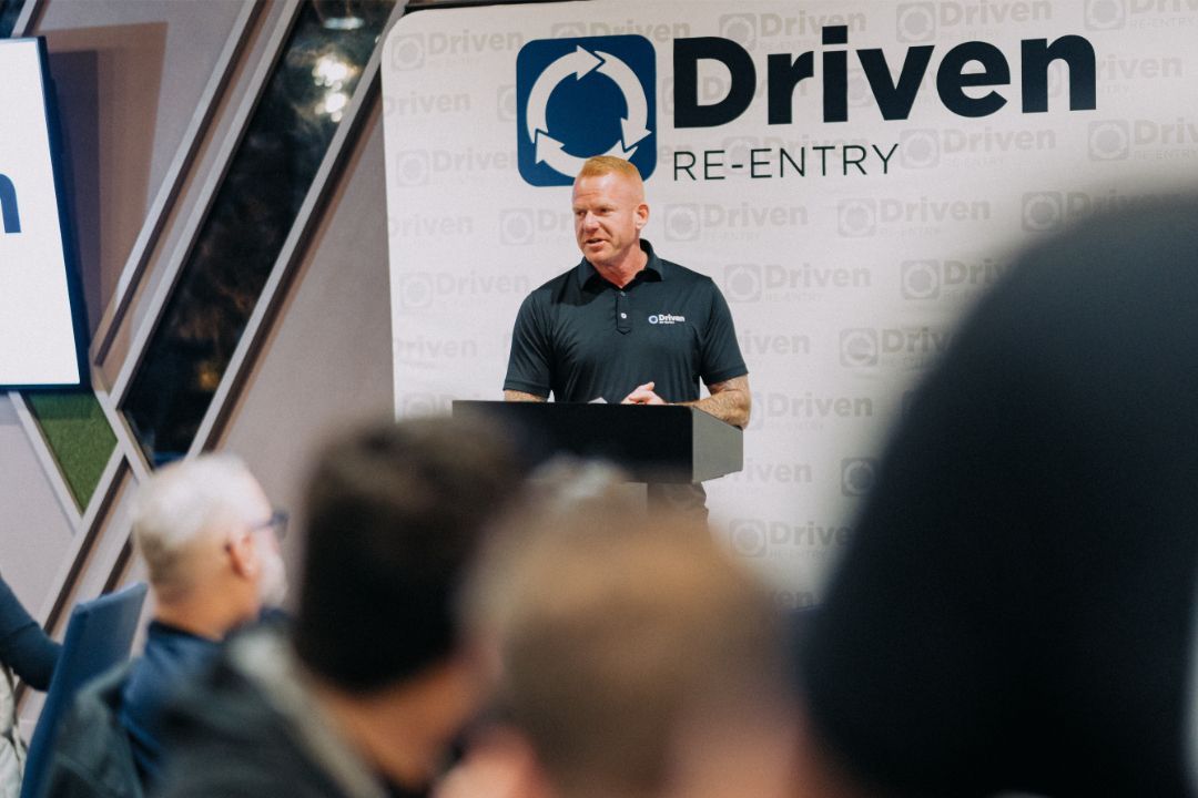 A man is standing at a podium giving a presentation to a group of people.