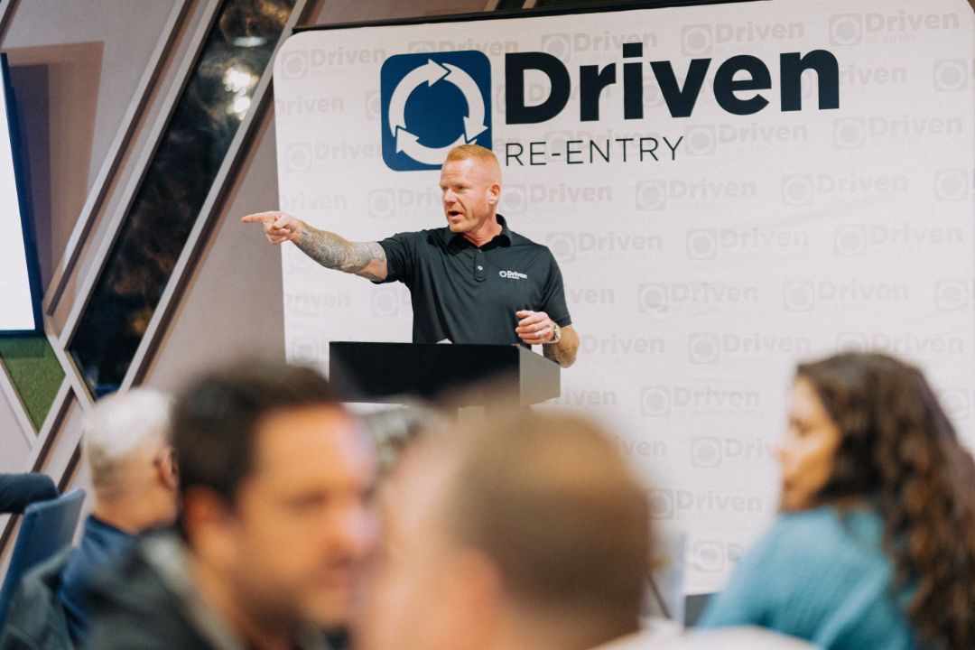 A man is standing at a podium giving a presentation to a group of people.