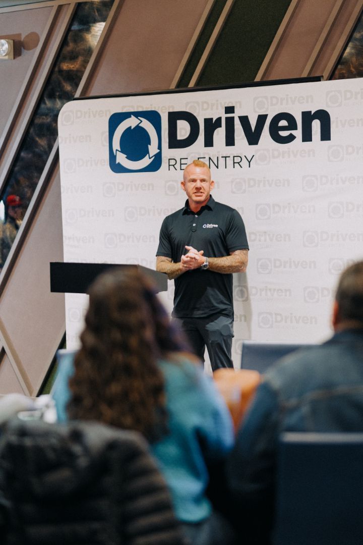 A man is standing at a podium giving a presentation to a group of people.