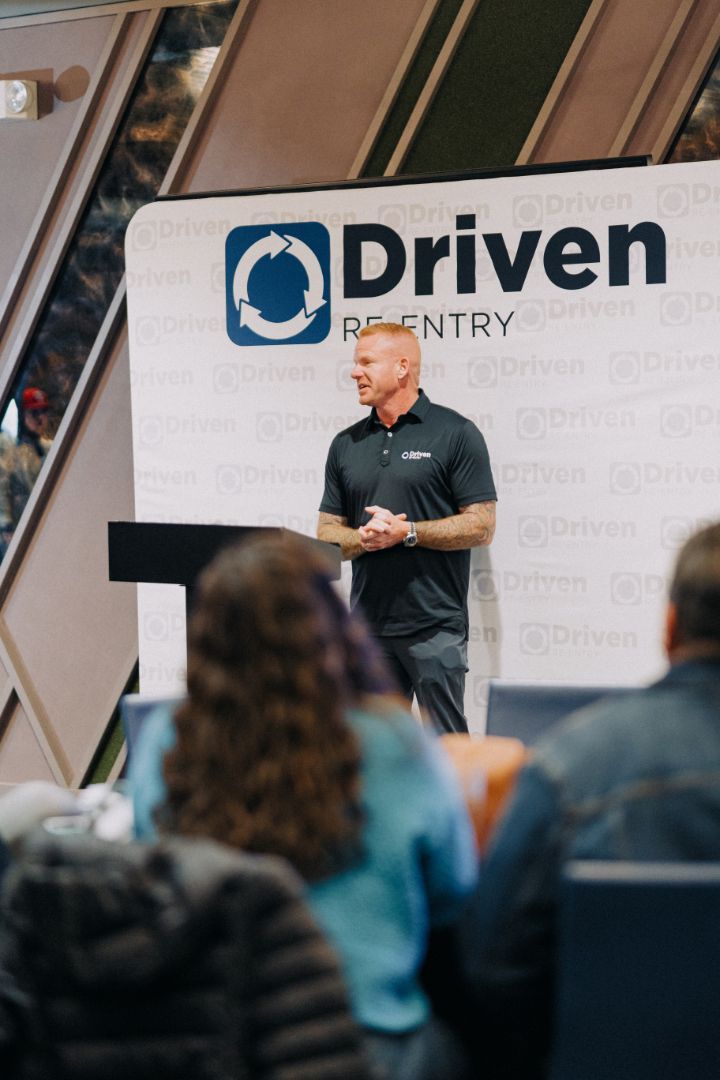 A man is standing at a podium giving a presentation to a group of people.