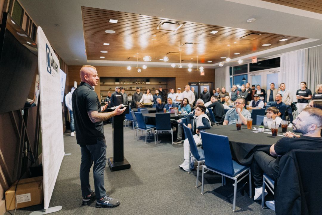 A man is giving a presentation to a large group of people in a conference room.