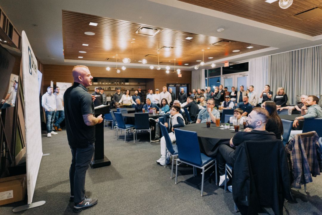 A man is giving a presentation to a large group of people in a conference room.