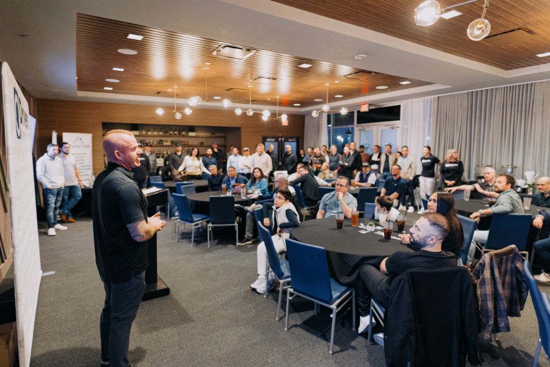 A man is giving a presentation to a large group of people in a conference room.