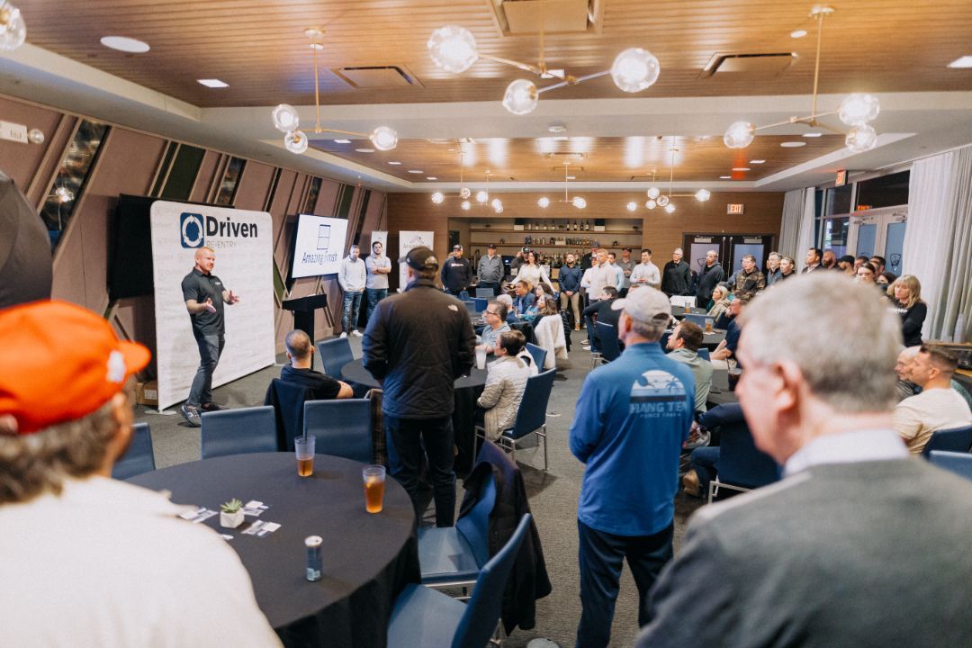 A group of people are sitting at tables in a large room.