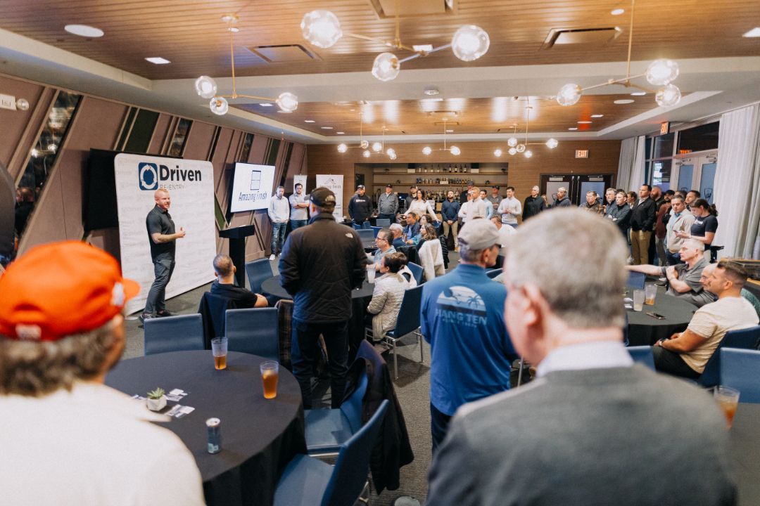 A group of people are sitting at tables in a large room.